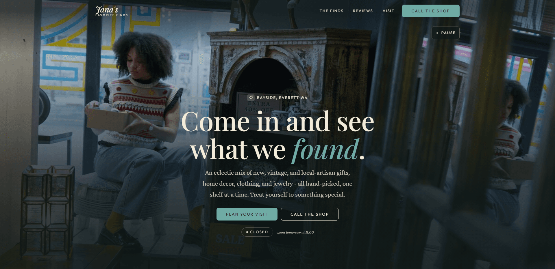 Homepage of Jana's Favorite Finds: a dark teal wash over a video still of a curly-haired young woman in a patterned sweater vest seated by a shop window opening a small box, beside a distressed wooden hutch holding blue-and-white china, under a top bar carrying the script 'Jana's' wordmark over the small capitals 'Favorite Finds', navigation reading The finds, Reviews, and Visit, a teal 'Call the shop' button, and a pause control for the background video beneath it, above a tag mark and the centered kicker 'Bayside, Everett WA', the large serif headline 'Come in and see what we found.' with its last word in teal italic, a line about an eclectic mix of new, vintage, and local-artisan gifts, home decor, clothing, and jewelry, all hand-picked one shelf at a time, a teal 'Plan your visit' button beside an outlined 'Call the shop' button, and a 'Closed' status pill beside the italic line 'opens tomorrow at 11:00'.