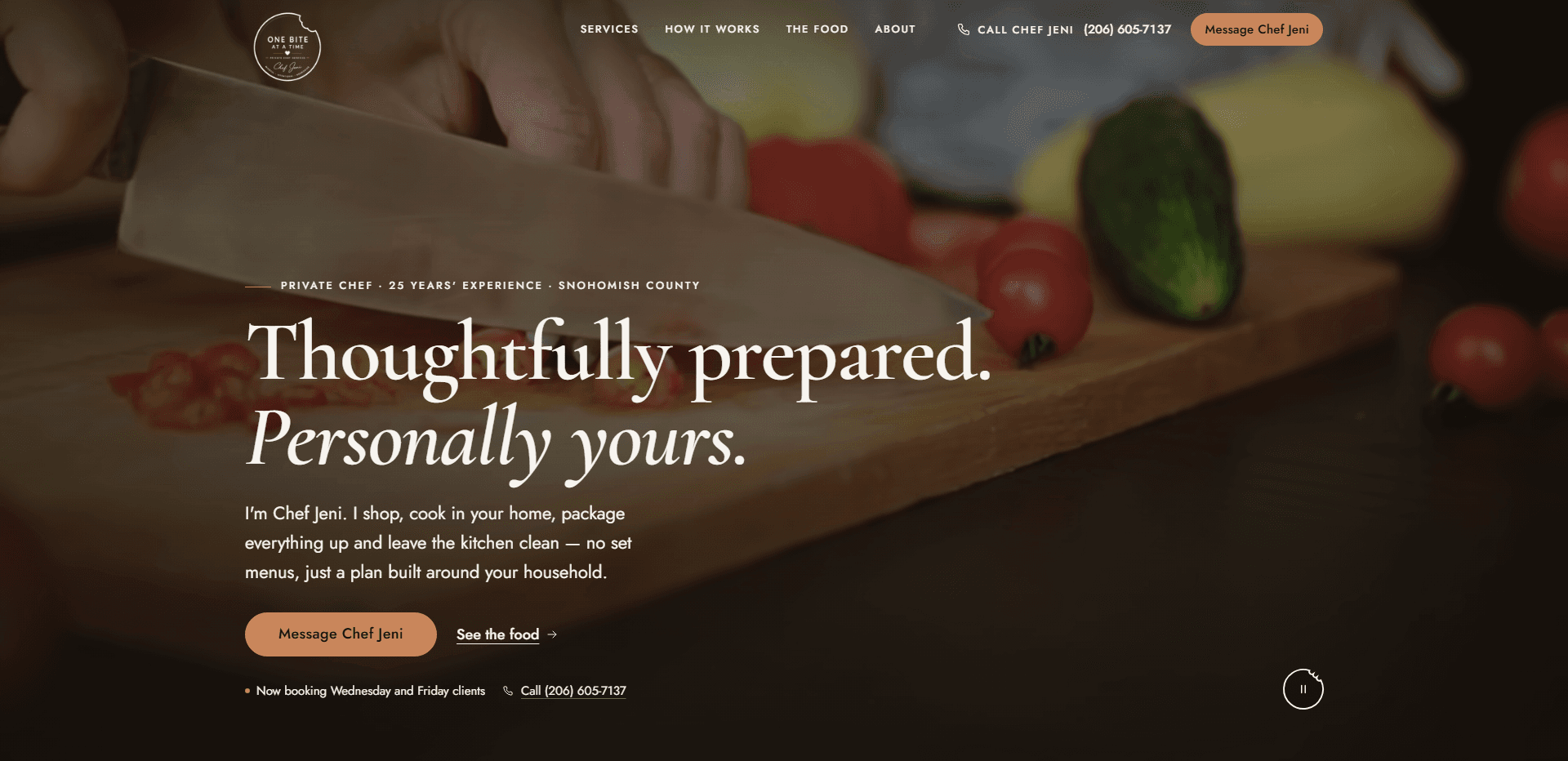 Homepage of One Bite at a Time: a dark, warm wash over a video still of a hand slicing cherry tomatoes with a chef's knife on a wooden cutting board beside a cucumber and a yellow squash, under a top bar carrying a round 'One Bite at a Time' badge logo, navigation reading Services, How it works, The food, and About, a 'Call Chef Jeni' phone number, and a copper 'Message Chef Jeni' button, above the kicker 'Private chef - 25 years' experience - Snohomish County', the serif headline 'Thoughtfully prepared. Personally yours.' with its second line in italic, a paragraph from Chef Jeni about shopping, cooking in your home, packaging everything up, and leaving the kitchen clean, a copper 'Message Chef Jeni' button beside a 'See the food' link, a line about booking Wednesday and Friday clients with the phone number, and a pause control for the background video in the corner.