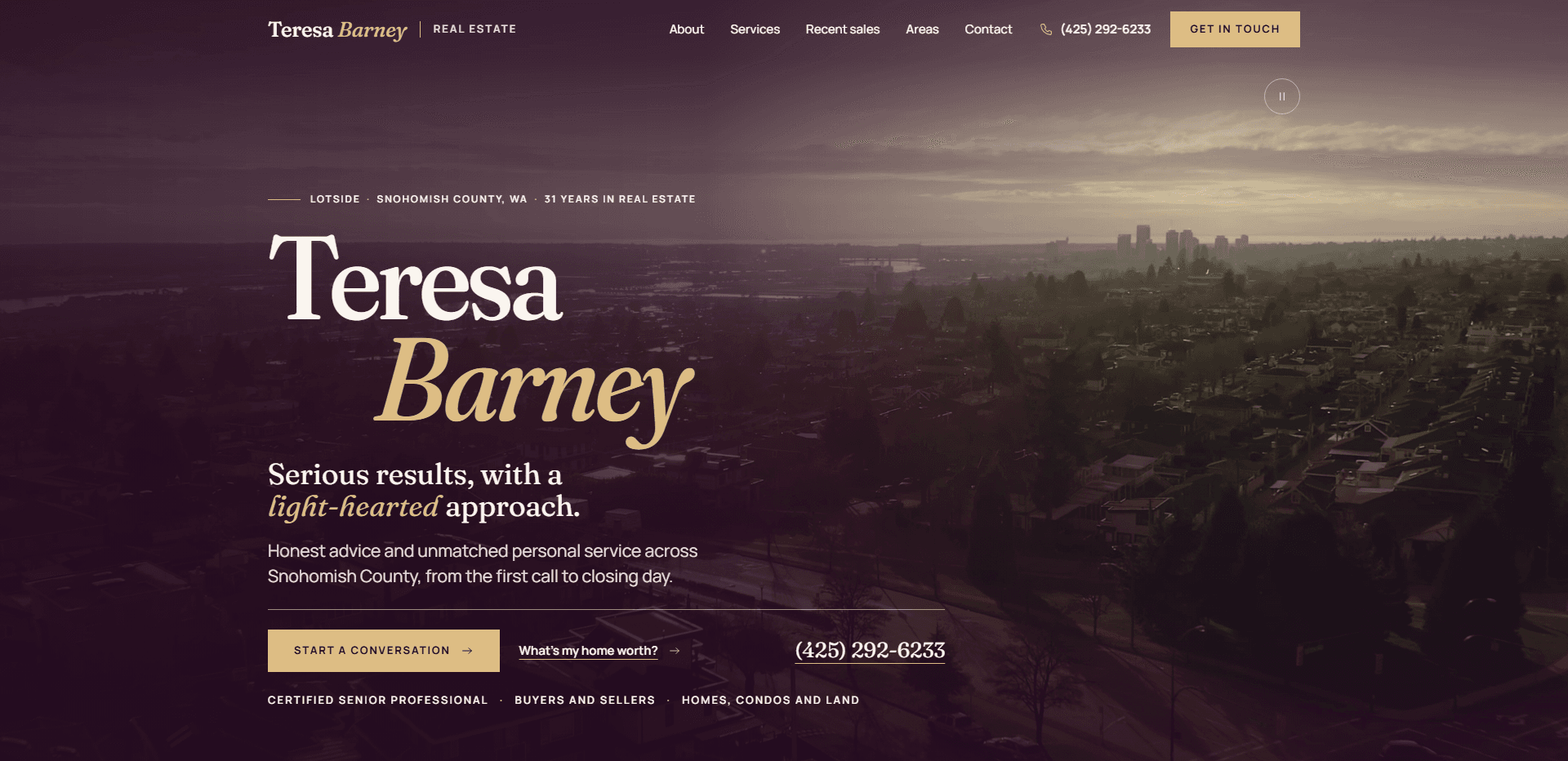 Homepage of Teresa Barney: a deep plum wash over an aerial video still of a wooded residential town at dusk with a city skyline on the horizon, under a top bar carrying a serif 'Teresa Barney Real Estate' wordmark, navigation reading About, Services, Recent sales, Areas, and Contact, a phone number, and a gold 'Get in touch' button, above the kicker 'Lotside - Snohomish County, WA - 31 years in real estate', the name 'Teresa Barney' set in oversized serif type with 'Barney' in gold italic, the line 'Serious results, with a light-hearted approach.', a paragraph about honest advice and personal service across Snohomish County, a gold 'Start a conversation' button, a 'What's my home worth?' link, and the phone number, over a row reading Certified Senior Professional, Buyers and sellers, and Homes, condos and land.