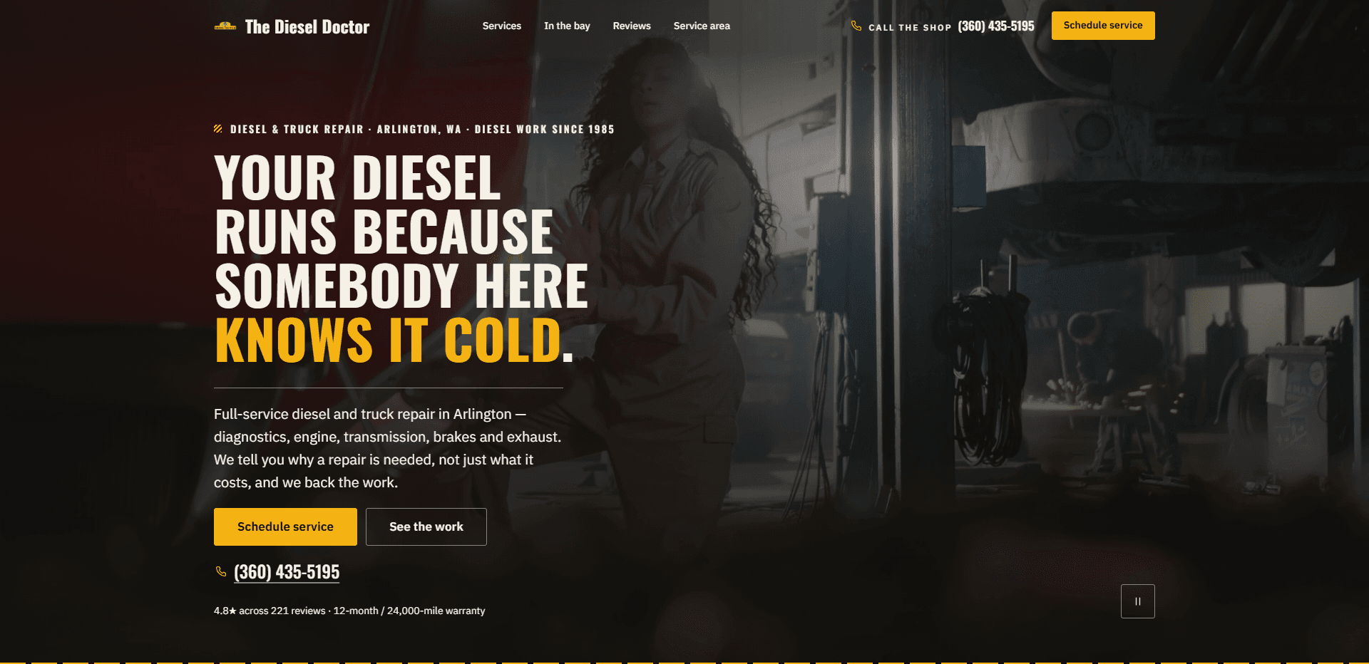 Homepage of The Diesel Doctor: a dark red-brown wash over a video still of a mechanic with long curly hair in work coveralls inside a truck repair bay, with a lift post, coiled air hoses, and a worker throwing grinder sparks behind, under a top bar carrying a small yellow truck mark beside the condensed 'The Diesel Doctor' wordmark, navigation reading Services, In the bay, Reviews, and Service area, a 'Call the shop' phone number, and a yellow 'Schedule service' button, above the kicker 'Diesel & truck repair - Arlington, WA - Diesel work since 1985', the oversized condensed capitals headline 'Your diesel runs because somebody here knows it cold.' with its last line in yellow, a paragraph about full-service diesel and truck repair in Arlington covering diagnostics, engine, transmission, brakes, and exhaust, and explaining why a repair is needed, a yellow 'Schedule service' button beside an outlined 'See the work' button, the phone number, a small line of review and warranty details, a pause control for the background video in the corner, and yellow-and-black hazard striping along the bottom edge.