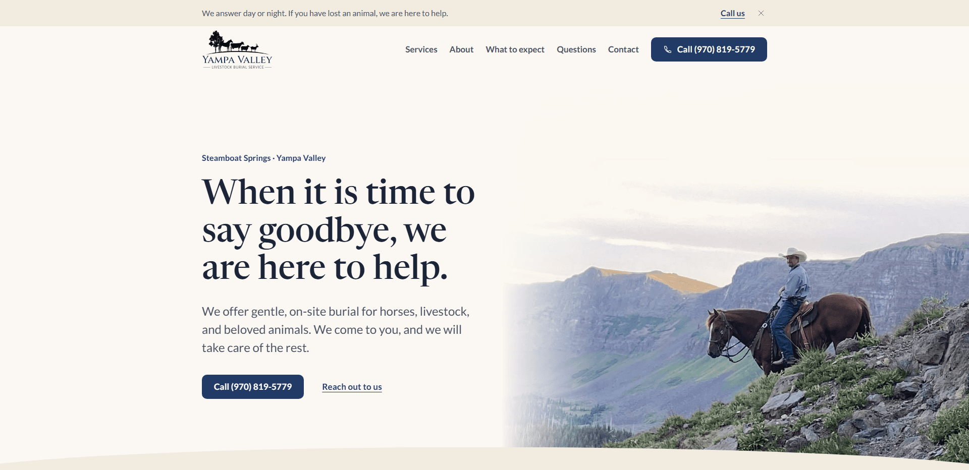 Homepage of Yampa Valley Livestock Burial Service: a warm cream page with a photograph of a rider in a cowboy hat on a chestnut horse at the edge of a rocky, grassy slope above a mountain valley fading in from the right, under a thin announcement bar reading 'We answer day or night. If you have lost an animal, we are here to help.' with a 'Call us' link and a close control, a top bar carrying a silhouette logo of a tree and a line of farm animals over the 'Yampa Valley' wordmark, navigation reading Services, About, What to expect, Questions, and Contact, and a navy 'Call' phone number button, above the kicker 'Steamboat Springs - Yampa Valley', the large serif headline 'When it is time to say goodbye, we are here to help.', a line about gentle, on-site burial for horses, livestock, and beloved animals, a navy 'Call' button with the phone number beside a 'Reach out to us' link, and a curved cream edge along the bottom.